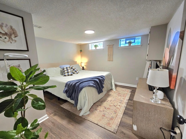 bedroom featuring dark hardwood / wood-style flooring and a textured ceiling