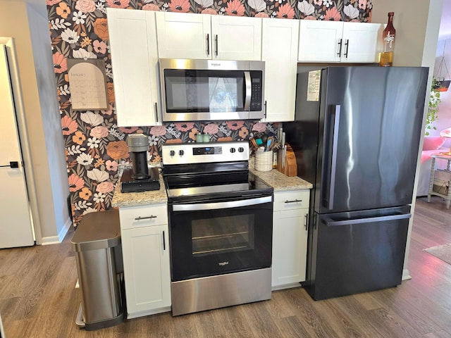 kitchen featuring dark hardwood / wood-style floors, appliances with stainless steel finishes, and white cabinets