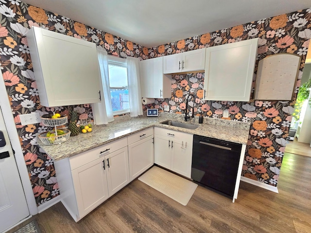 kitchen featuring light stone countertops, white cabinets, dishwasher, dark hardwood / wood-style flooring, and sink