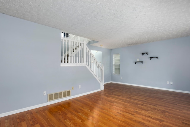 empty room featuring a textured ceiling and hardwood / wood-style flooring