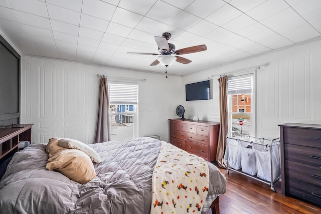 bedroom with ceiling fan, dark hardwood / wood-style floors, and multiple windows