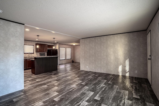 unfurnished living room featuring a textured ceiling and dark hardwood / wood-style floors