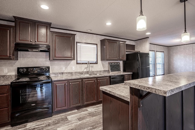 kitchen with black appliances, sink, crown molding, dark brown cabinetry, and hanging light fixtures