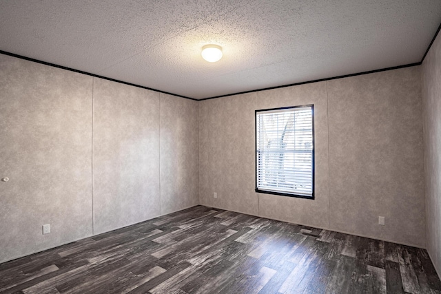 spare room with a textured ceiling, dark hardwood / wood-style flooring, and crown molding