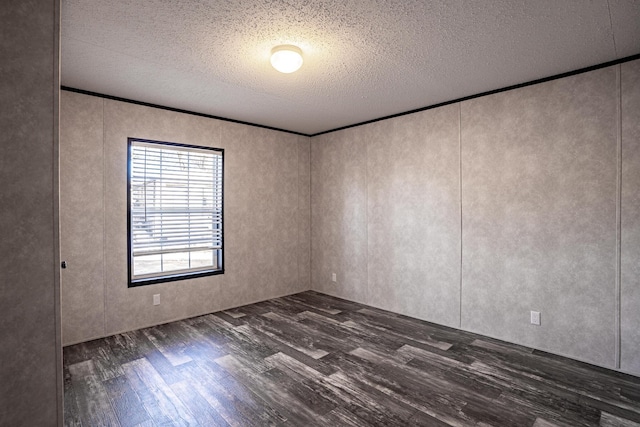 unfurnished room with dark hardwood / wood-style floors, a textured ceiling, and ornamental molding