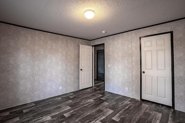 unfurnished bedroom featuring a textured ceiling and dark wood-type flooring