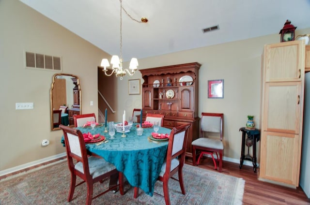 dining room with lofted ceiling, a notable chandelier, and light wood-type flooring