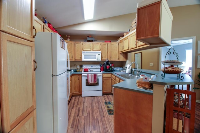 kitchen with kitchen peninsula, light brown cabinets, white appliances, vaulted ceiling, and sink