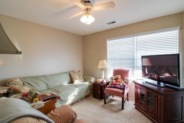 carpeted living room with ceiling fan