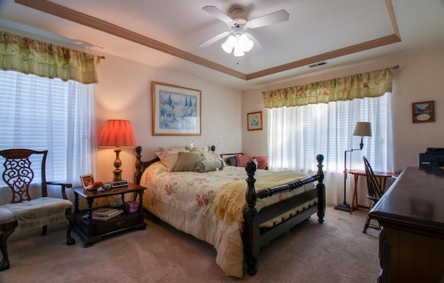 bedroom with ceiling fan, carpet, and a raised ceiling