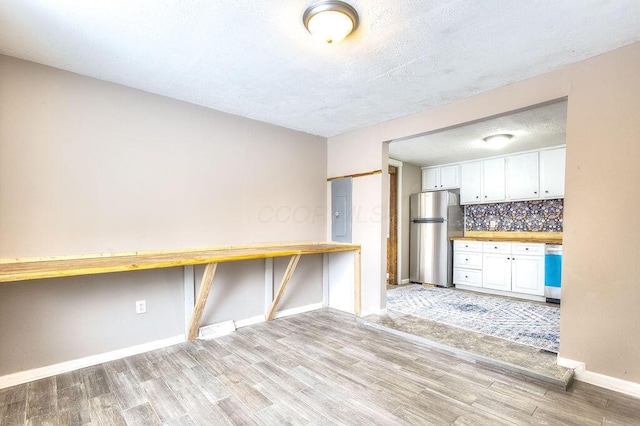 kitchen featuring a textured ceiling, white cabinetry, stainless steel appliances, backsplash, and butcher block countertops