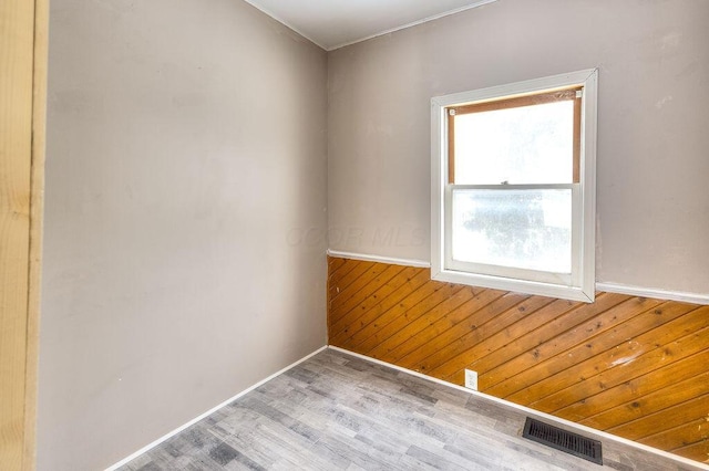 empty room featuring hardwood / wood-style floors and wood walls