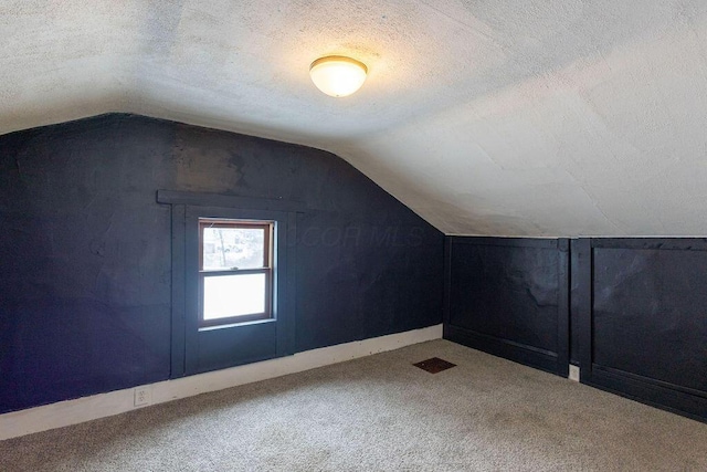 bonus room with a textured ceiling, carpet, and vaulted ceiling