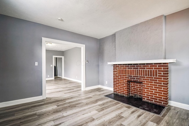 unfurnished living room featuring wood-type flooring and a textured ceiling