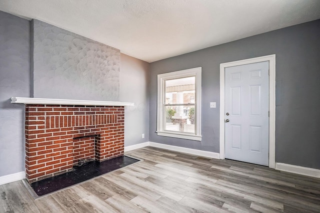 unfurnished living room with wood-type flooring and a textured ceiling