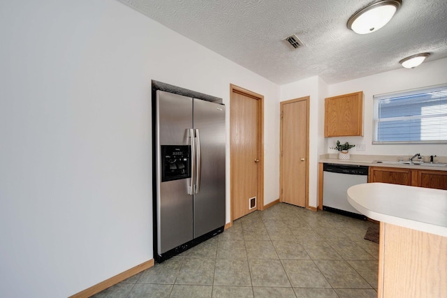 kitchen featuring sink, a textured ceiling, and stainless steel appliances