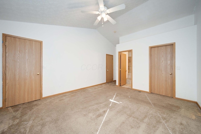 unfurnished bedroom with a textured ceiling, ceiling fan, carpet flooring, and lofted ceiling