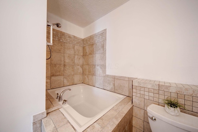 bathroom featuring toilet, a textured ceiling, and tiled tub