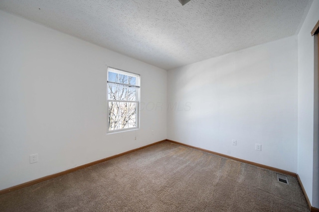 carpeted empty room with a textured ceiling