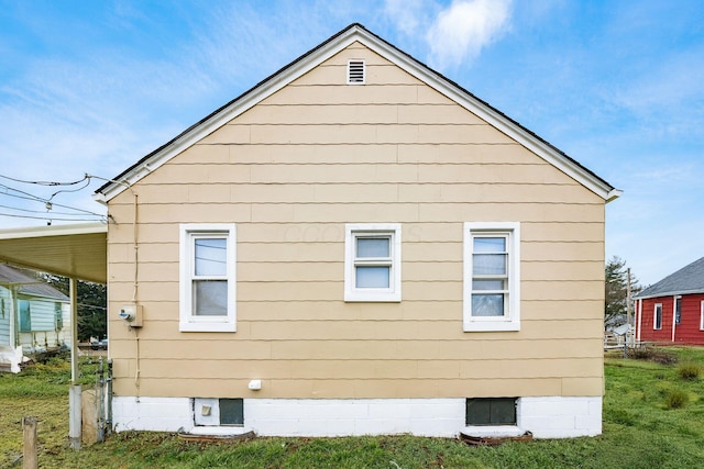 view of side of home with a yard