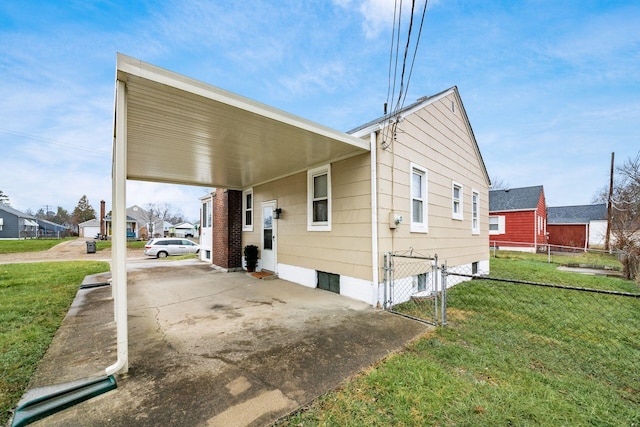 view of side of home featuring a carport and a lawn