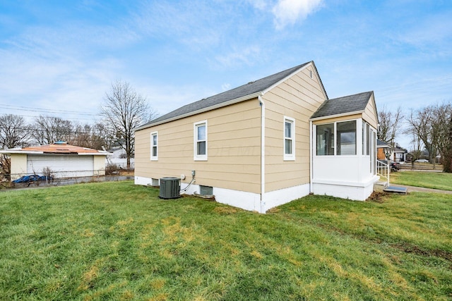 view of side of home with a lawn, a sunroom, and central air condition unit