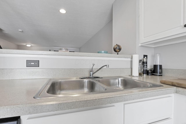 kitchen featuring white cabinetry and sink