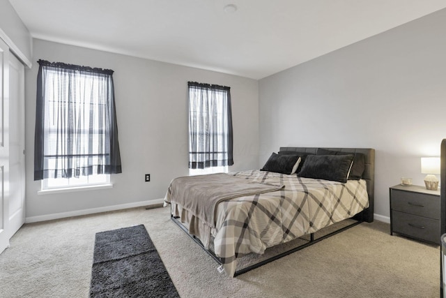 bedroom with multiple windows and light carpet