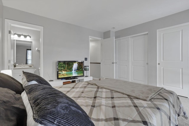 bedroom with connected bathroom and carpet floors