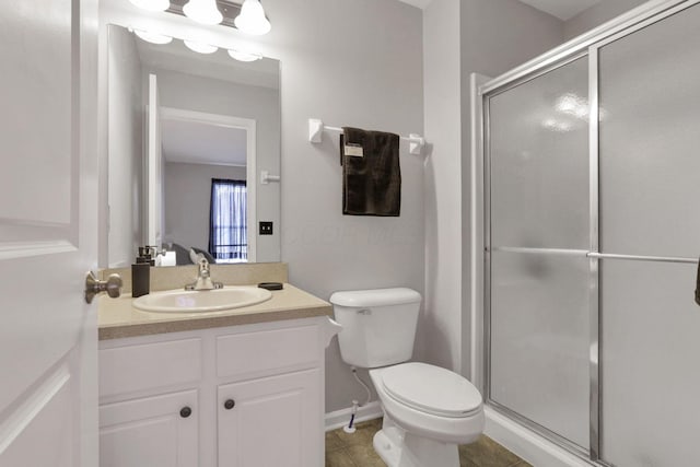 bathroom with a shower with shower door, vanity, and toilet