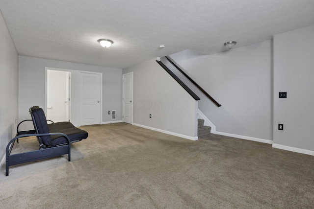 living area with carpet and a textured ceiling