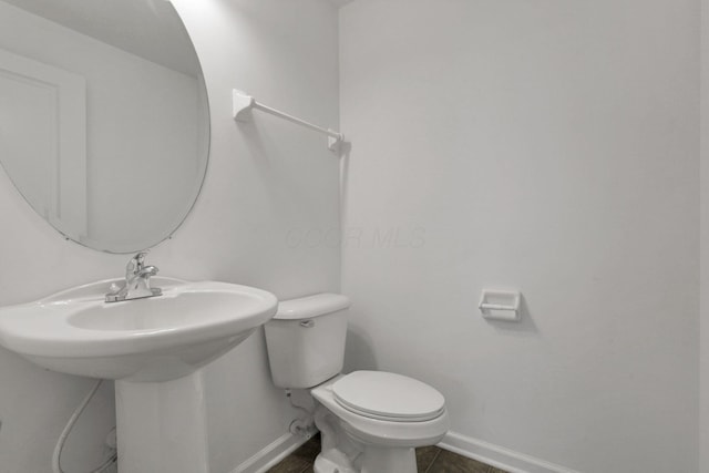 bathroom with toilet and tile patterned flooring