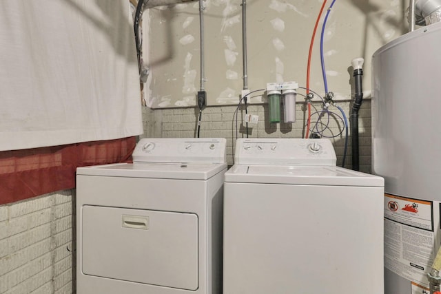 clothes washing area with washer and dryer and water heater