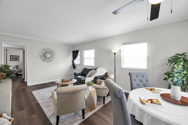 living area with a ceiling fan, dark wood finished floors, and baseboards