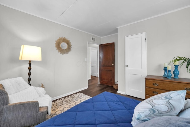 bedroom with baseboards, visible vents, wood finished floors, and ornamental molding