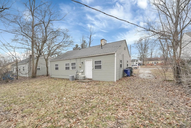 back of property featuring roof with shingles and a chimney