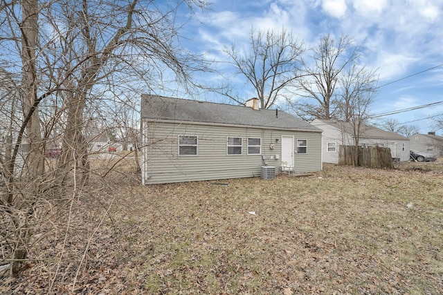 back of house featuring a yard, a chimney, and central air condition unit