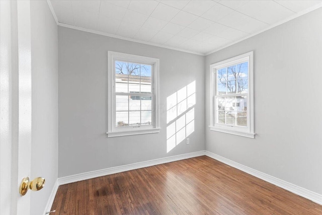 empty room featuring ornamental molding and hardwood / wood-style floors