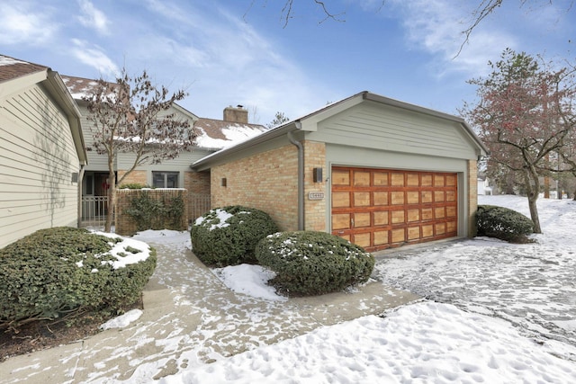 view of snowy exterior featuring a garage