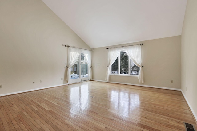 unfurnished living room featuring high vaulted ceiling and light hardwood / wood-style floors