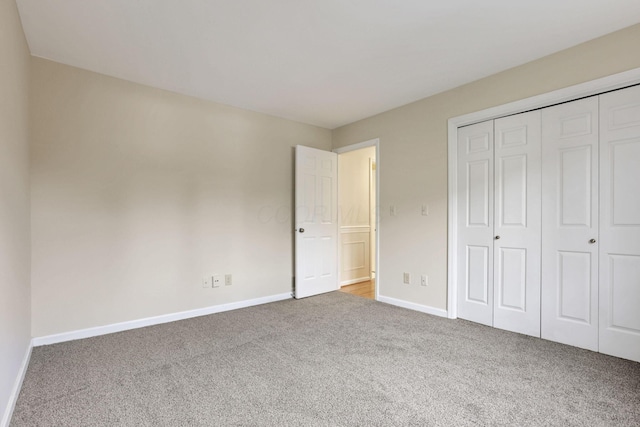 unfurnished bedroom featuring carpet flooring and a closet