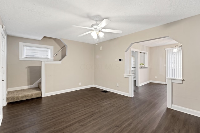 spare room with dark wood-type flooring, ceiling fan, and a textured ceiling