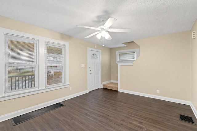 entryway featuring ceiling fan, dark hardwood / wood-style floors, and a textured ceiling