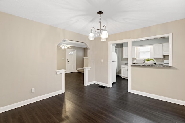 interior space featuring dark hardwood / wood-style floors and ceiling fan with notable chandelier