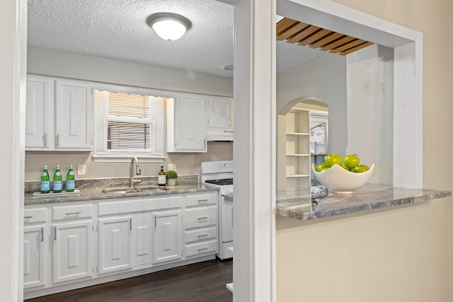 kitchen with light stone countertops, sink, white range with gas stovetop, and white cabinets