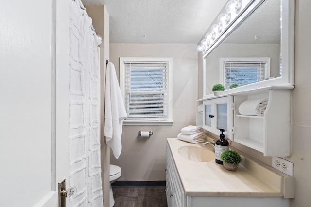 bathroom with vanity, a textured ceiling, and toilet