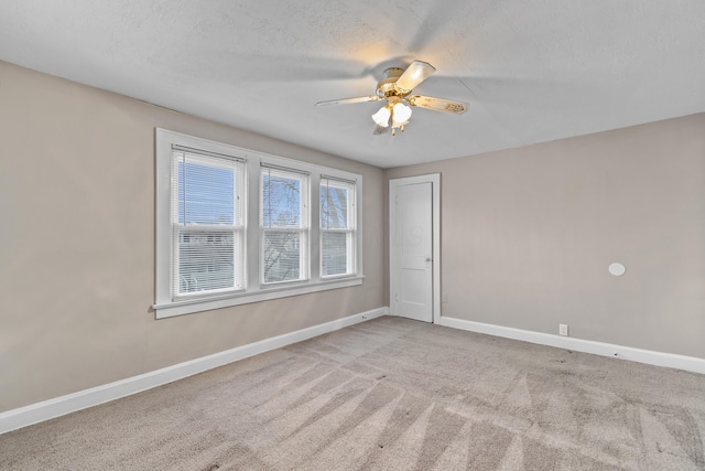 carpeted spare room with ceiling fan and a textured ceiling