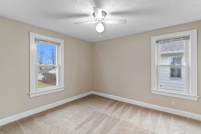 carpeted empty room featuring a textured ceiling and ceiling fan