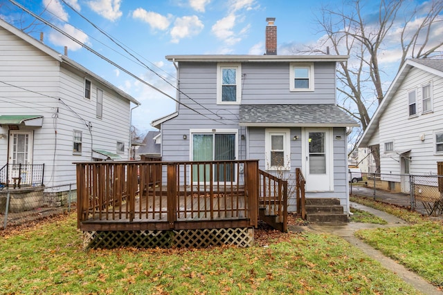 back of property featuring a wooden deck and a yard