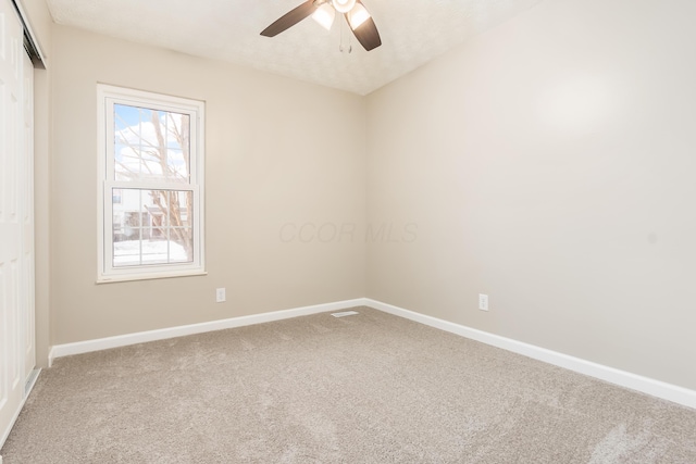 carpeted spare room featuring ceiling fan